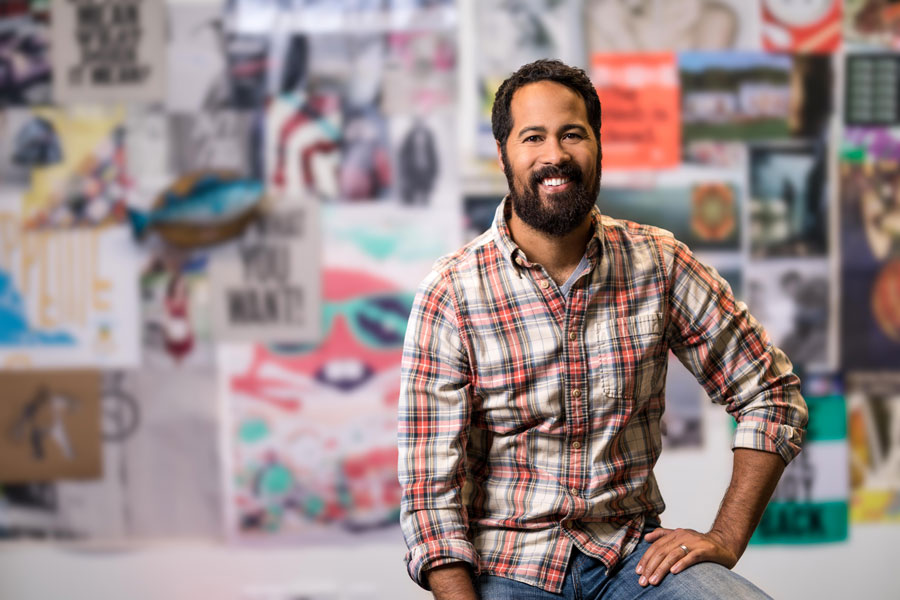 Bearded man in a flannel shirt smiles at the camera