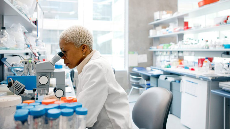 Scientist using a microscope in a lab