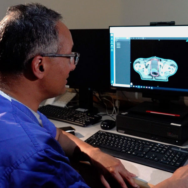 NHS consultant, Dr Raj Jena, inspects radiology scans on his computer