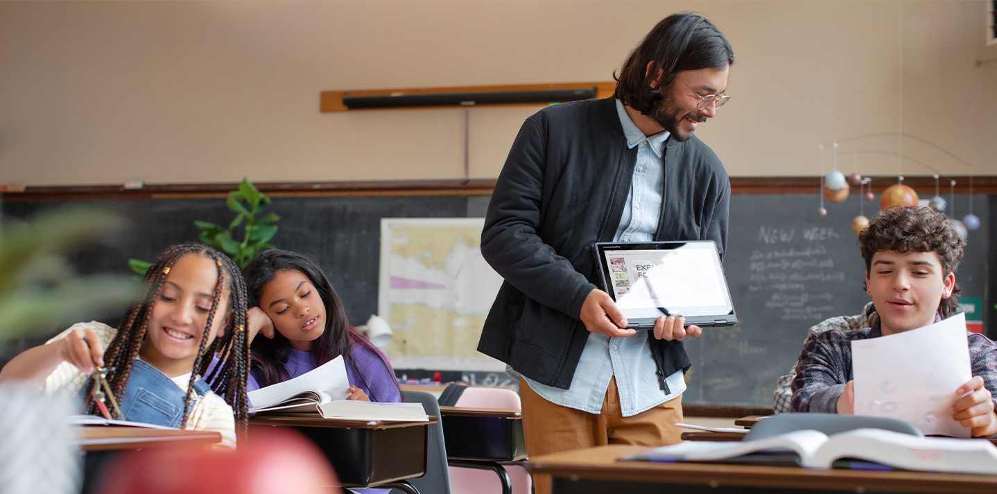 Teacher in classroom holding tablet